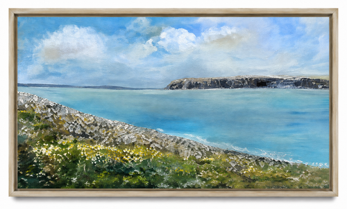 Flaggy Shore, Mermaid Bay by Anna de Marigny, an oil painting of a turquoise bay with a limestone shore and wildflowers, in a pale wood frame.